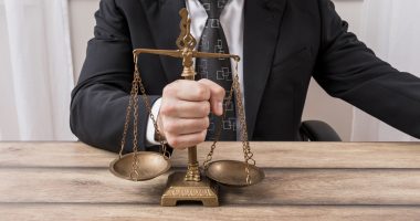 Advogado segurando balança da justiça, simbolizando a elaboração de um código de conduta empresarial para prevenção de litígios.