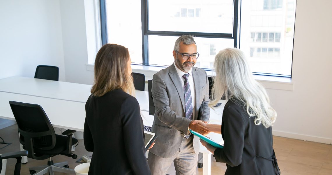 Sócios em reunião corporativa formalizando acordos e alinhando decisões estratégicas por meio do planejamento societário empresarial.