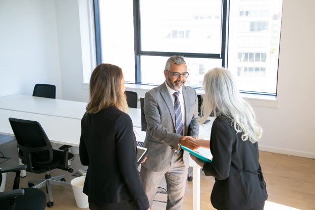 Sócios em reunião corporativa formalizando acordos e alinhando decisões estratégicas por meio do planejamento societário empresarial.
