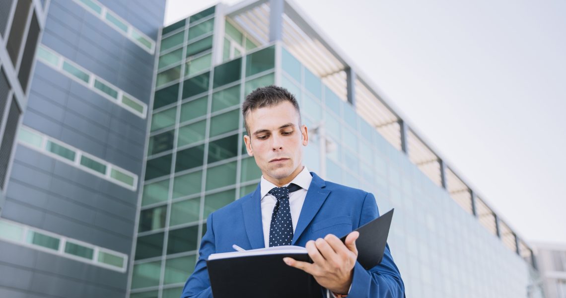 Advogado direito administrativo analisando documentos empresariais em frente a prédio corporativo moderno