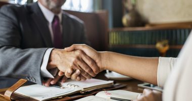 Aperto de mãos entre profissionais durante negociação empresarial, representando o processo de due diligence jurídica e a tomada de decisões seguras.