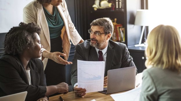sócios e advogado analisando saída de sócio da empresa em reunião corporativa