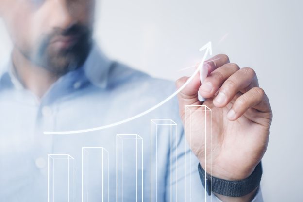 Empresário acompanhando o crescimento de indicadores financeiros, representando o crescimento empresarial aliado ao planejamento jurídico e à gestão estratégica.